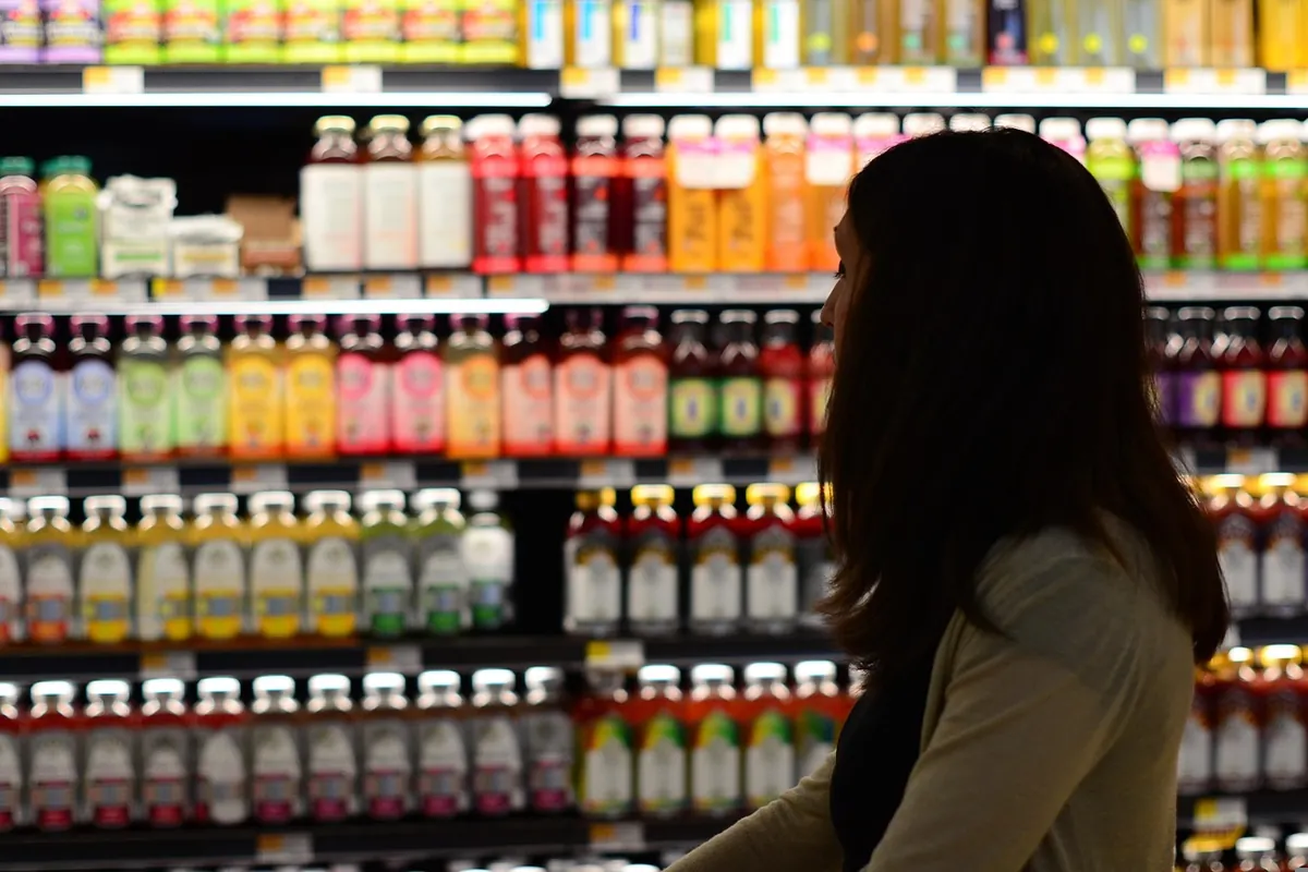 A shopper beside shelves of bottled drinks