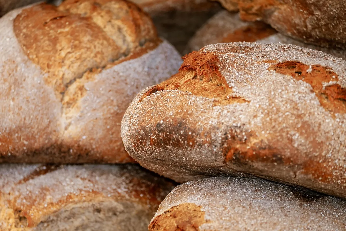 Loaves of bread stacked on a wooden board