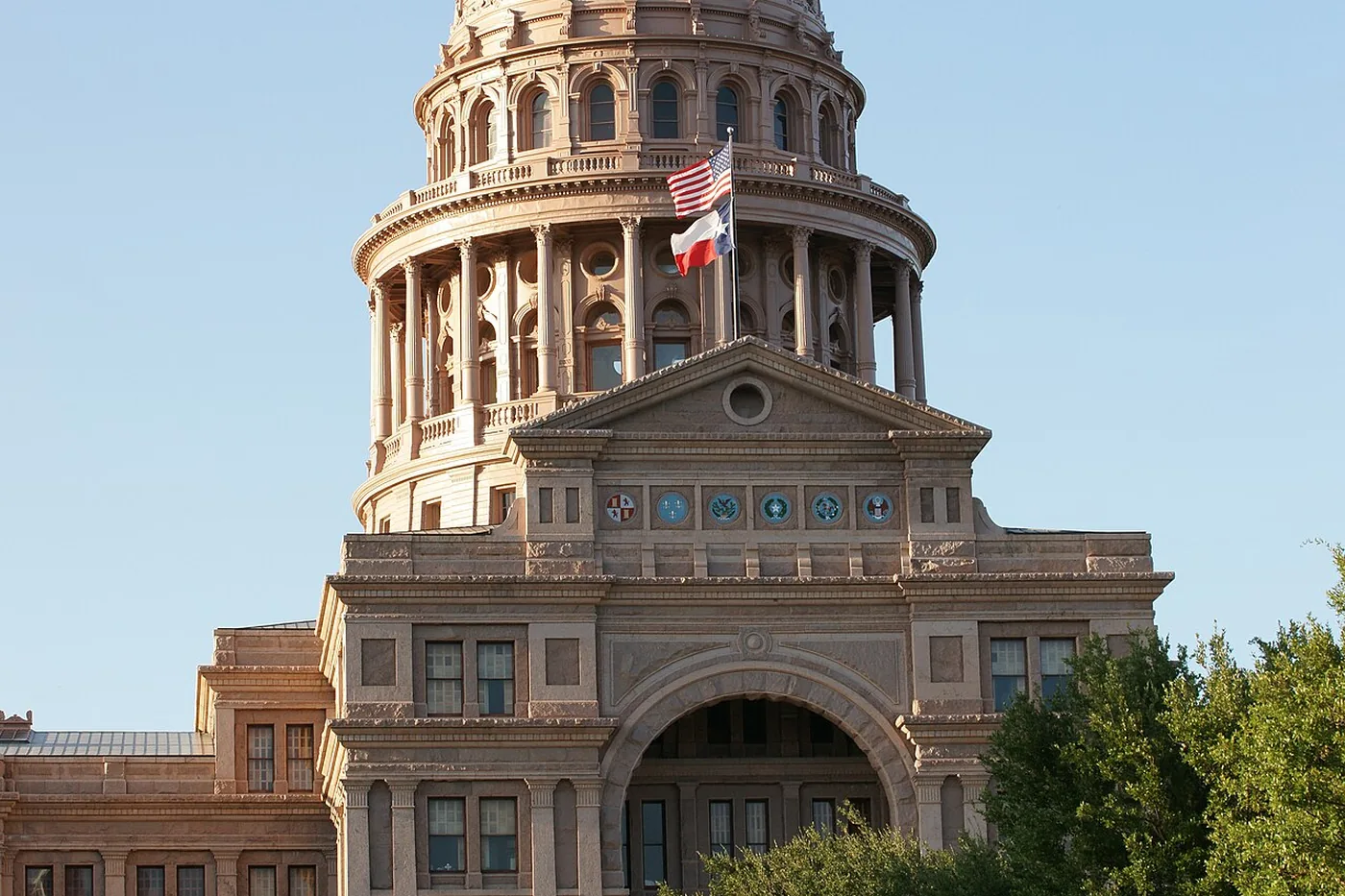 The Texas State Capitol dome and front arch, with two flags