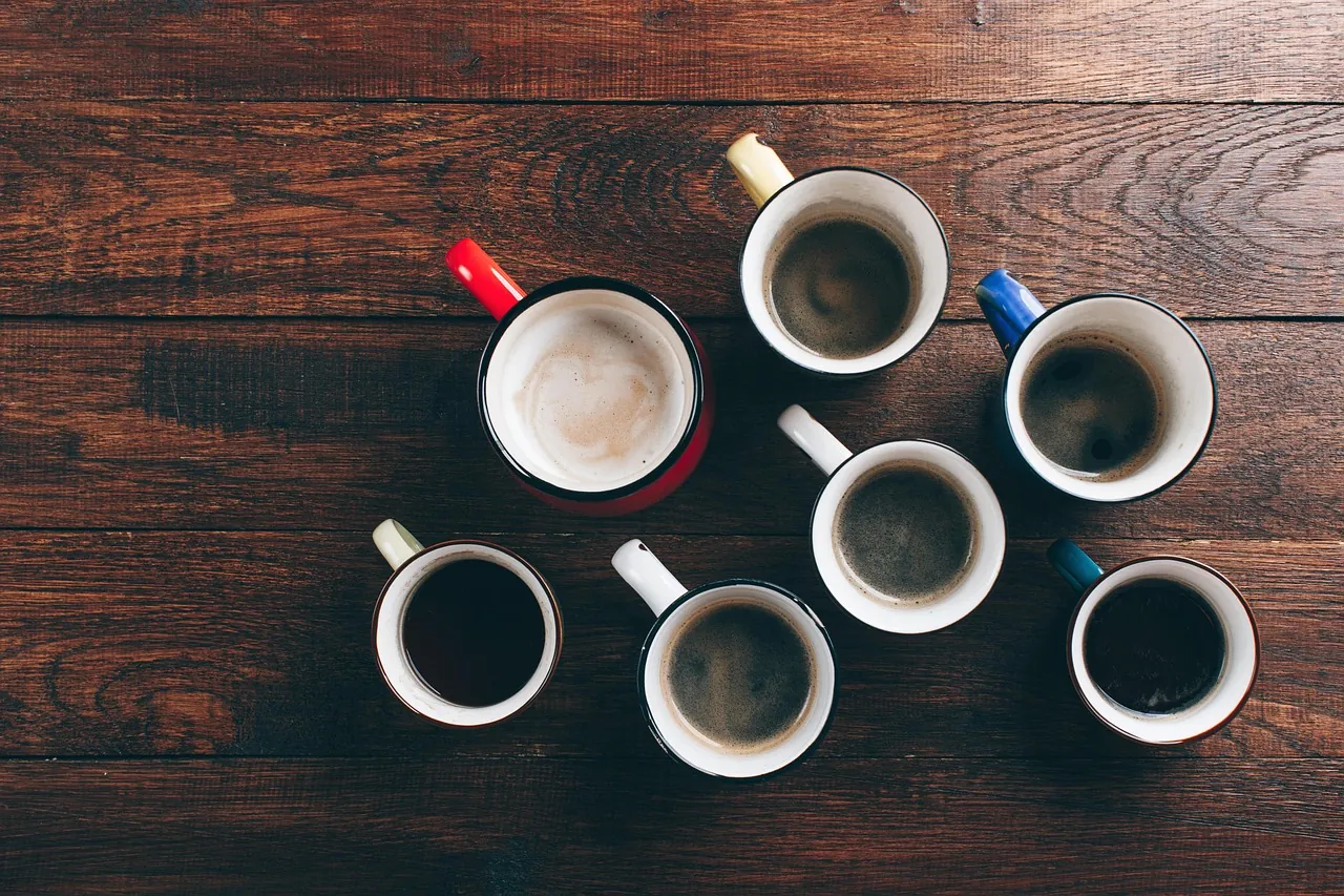 Several coffee cups on a dark wooden table