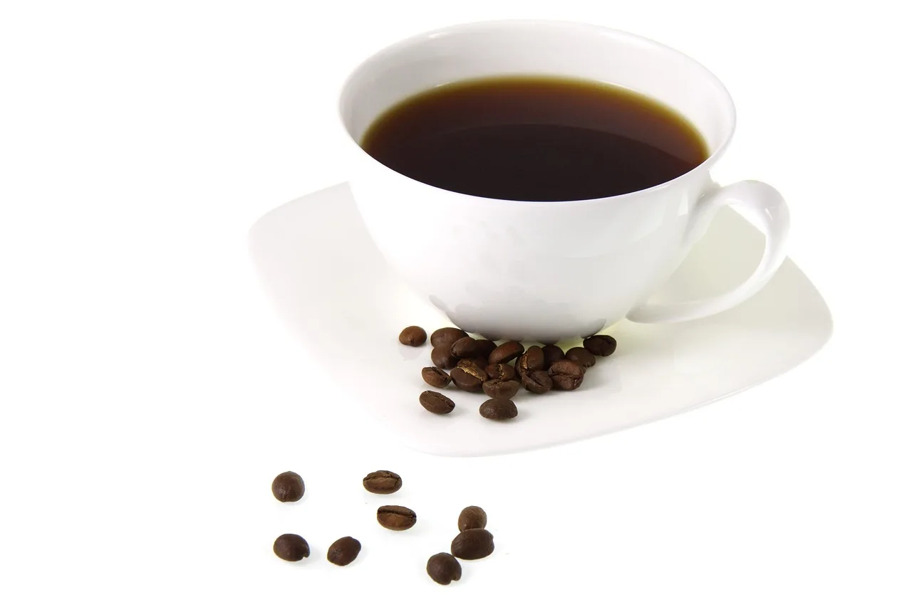 A white cup of coffee with beans on the saucer