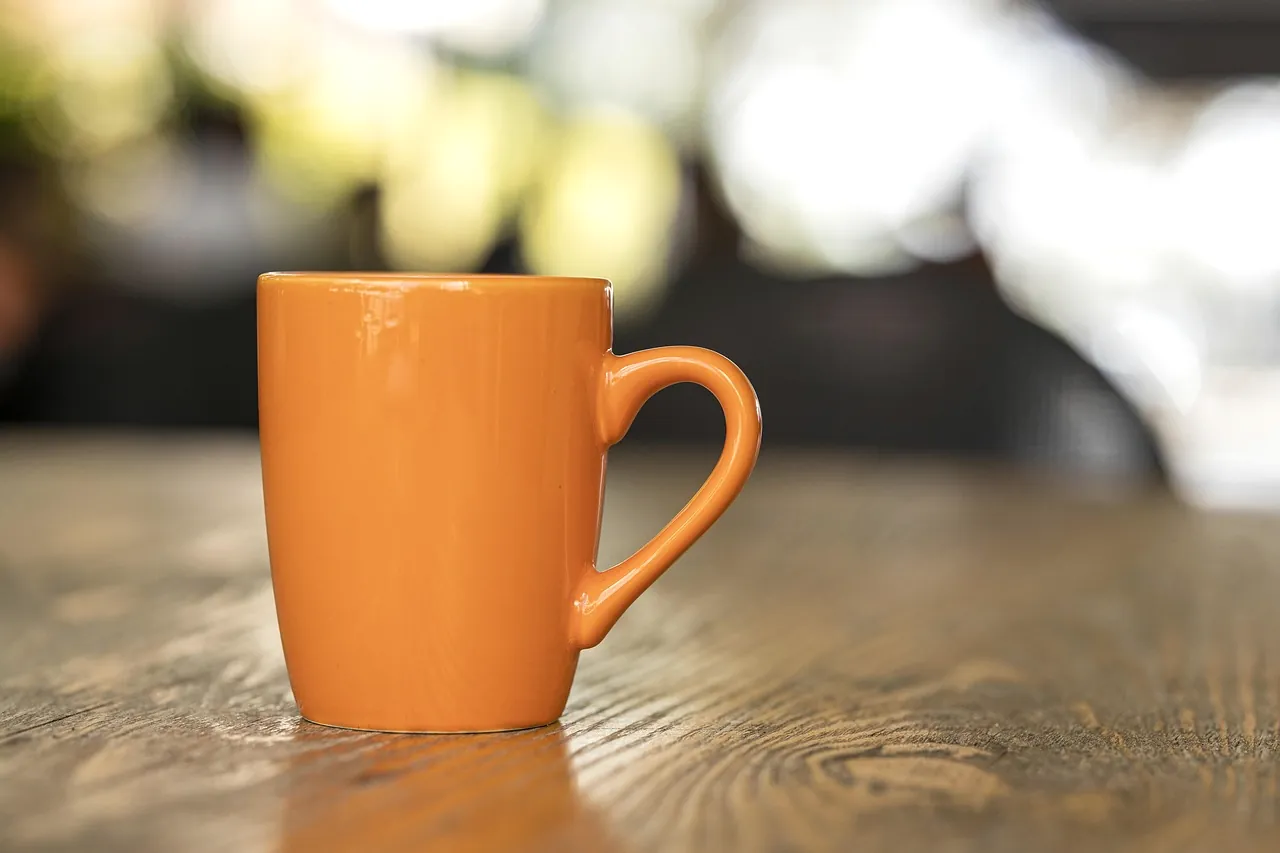 Coffee, a cup, and breakfast on a wooden table