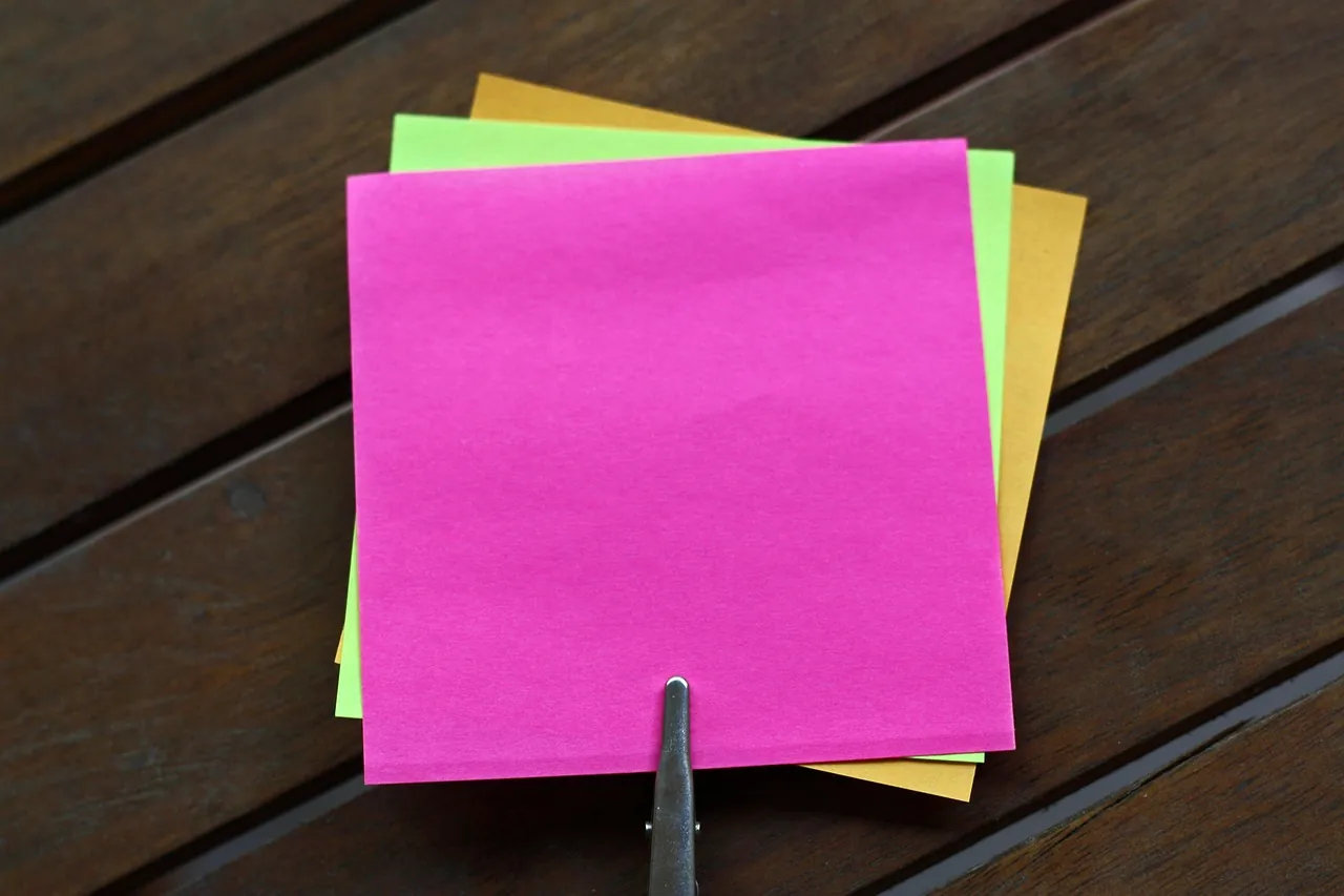 A stack of blank colored notes held by a clip