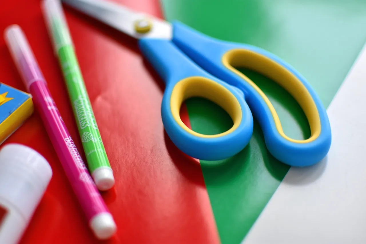 Colored pens and a pair of scissors on a table