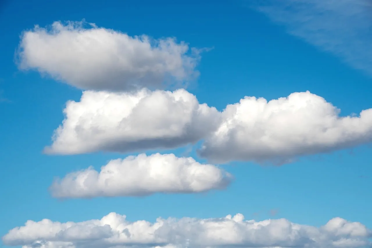 Layered white clouds in a clear blue sky