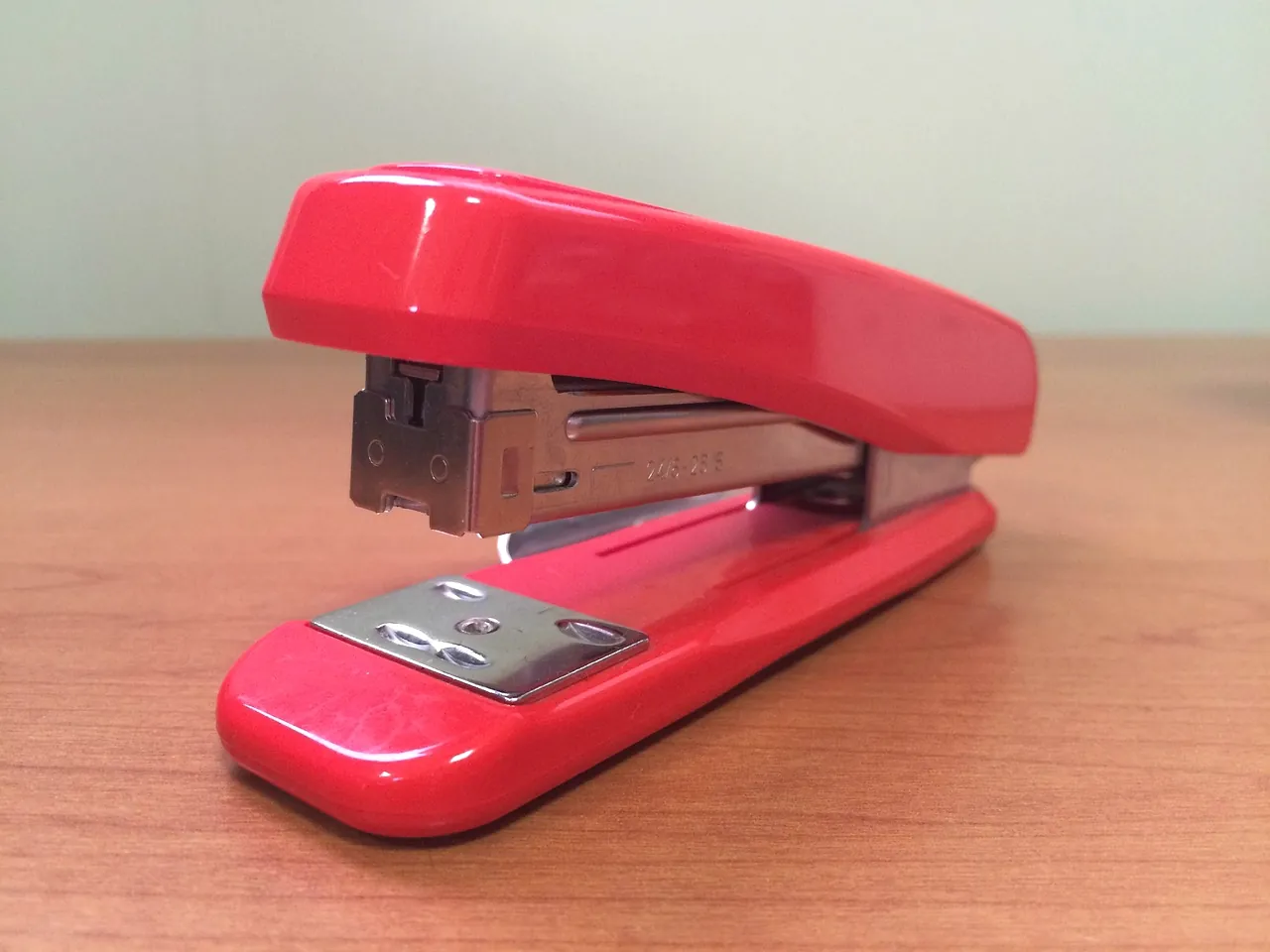 A stapler beside a short stack of paper
