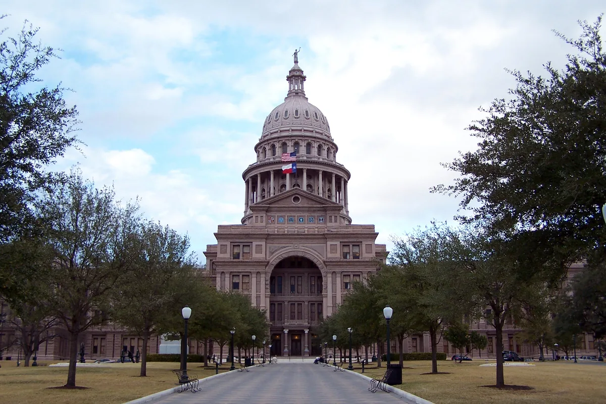 The Texas State Capitol in Austin, dome and flags above the front walk.
