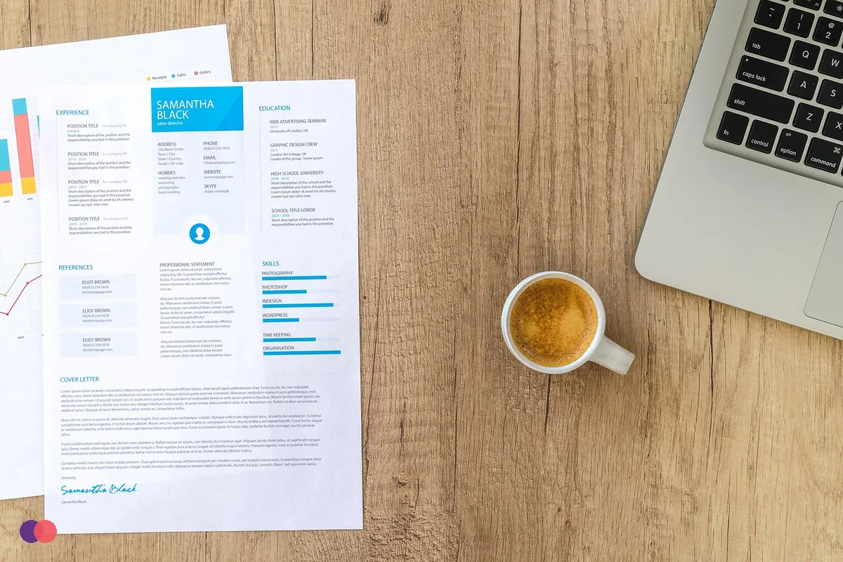 Printed pages, a laptop and a cup of coffee on a wooden table