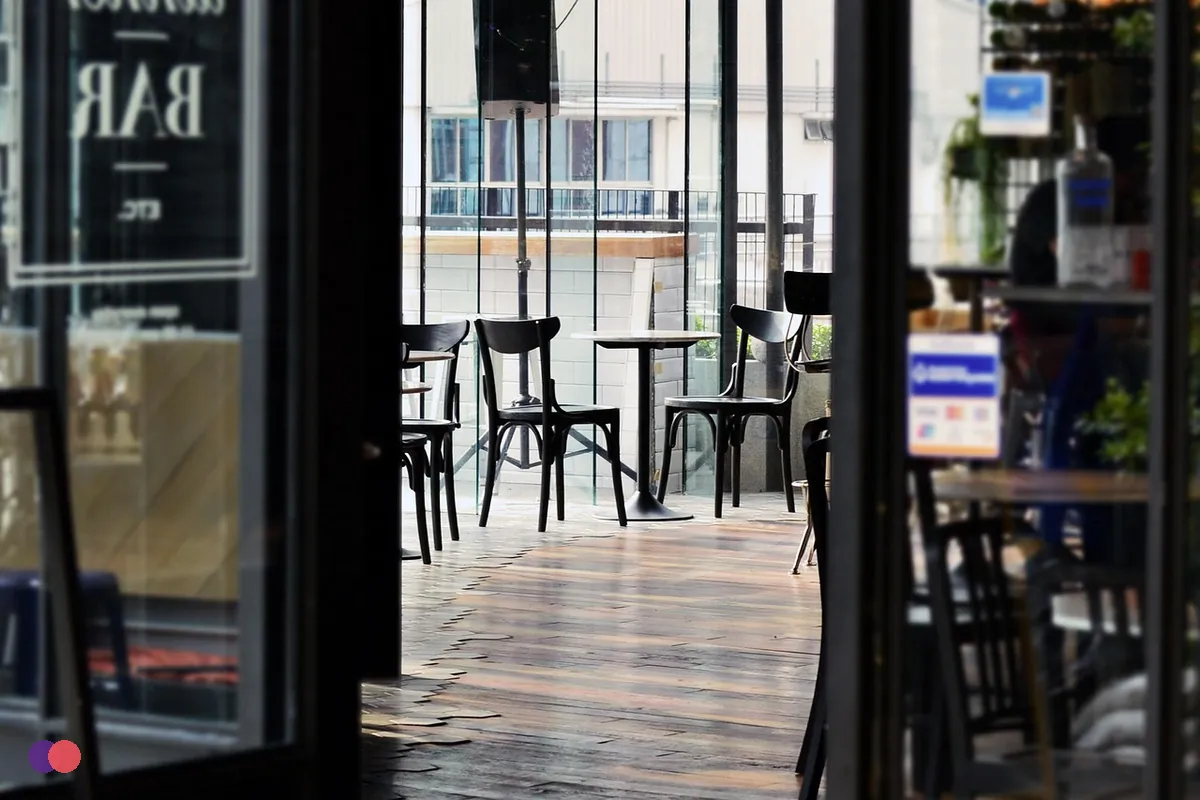 An open shop door in the morning with the lights on and nobody yet inside