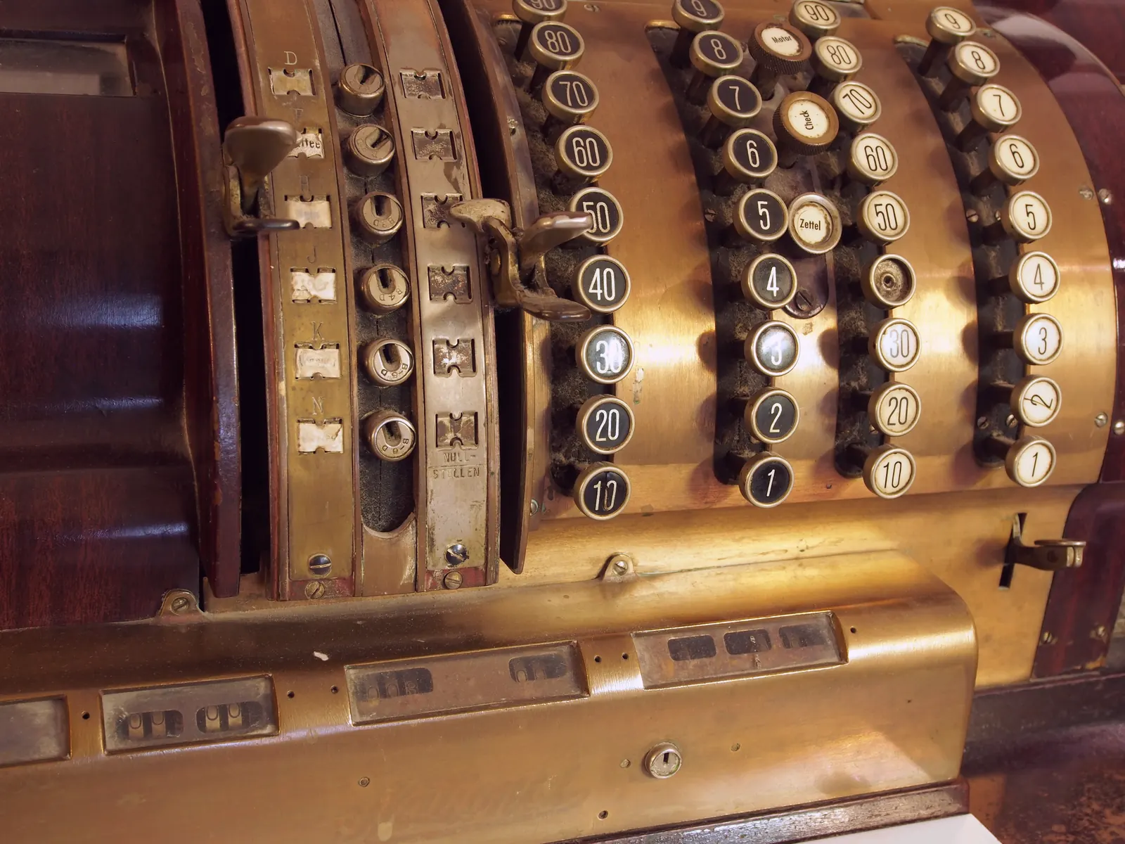 Rows of numbered keys on a brass cash register, each key a separate choice a person can press.